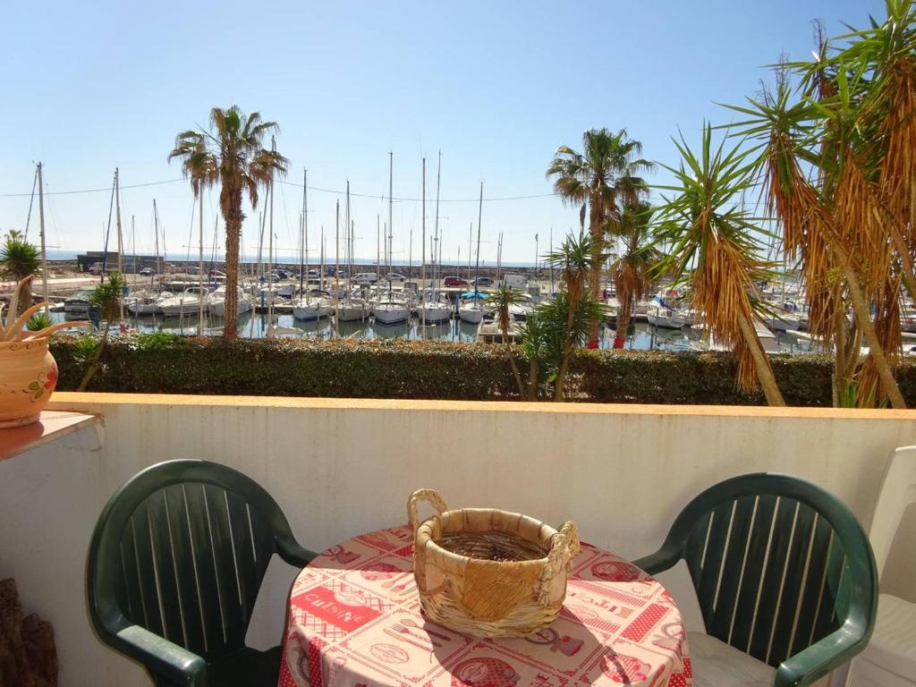 a table with a basket on a balcony with a marina at Appartement Le Barcarès, 2 pièces, 4 personnes - FR-1-782-36 in Le Barcarès