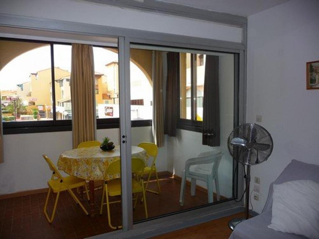 une pièce avec une table, des chaises et une fenêtre dans l'établissement Studio Cabine avec Terrasse, Accès Direct Plage, Plein Centre Le Barcarès, Équipé pour 4 Pers - FR-1-782-15, au Barcarès