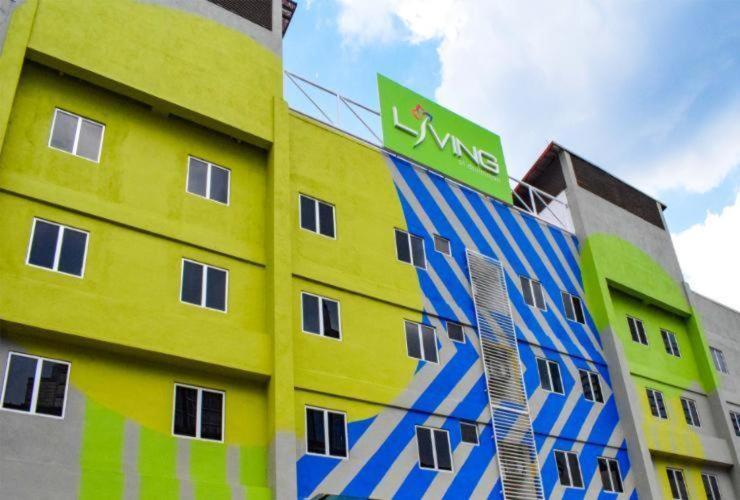 Living At DSulaiman Hotel في كوالالمبور: مبنى أصفر وأزرق عليه علامة خضراء