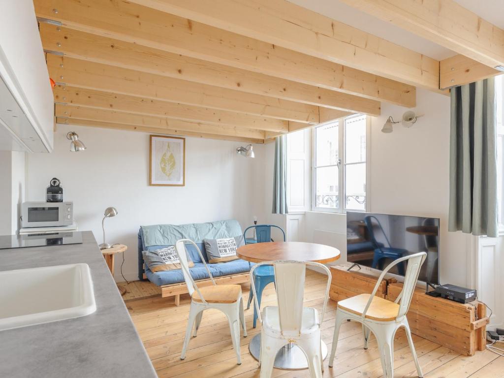 cocina y sala de estar con mesa y sillas en Studio La Rochelle, 1 pièce, 2 personnes - FR-1-535-54, en La Rochelle