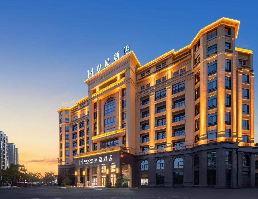 un edificio de oficinas con una fachada iluminada en Mehood Hotel Huangshan High-Speed North Station, en Huangshan