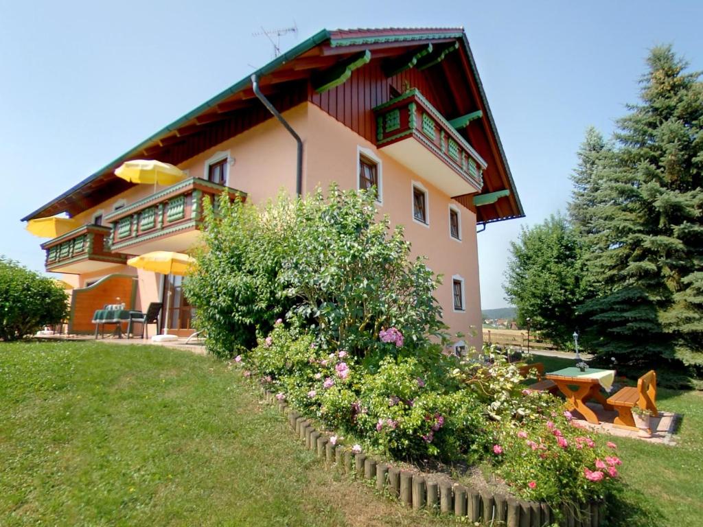 ein großes Haus mit Balkon und einigen Blumen in der Unterkunft Ferienwohnung Cornelia in Bad Birnbach