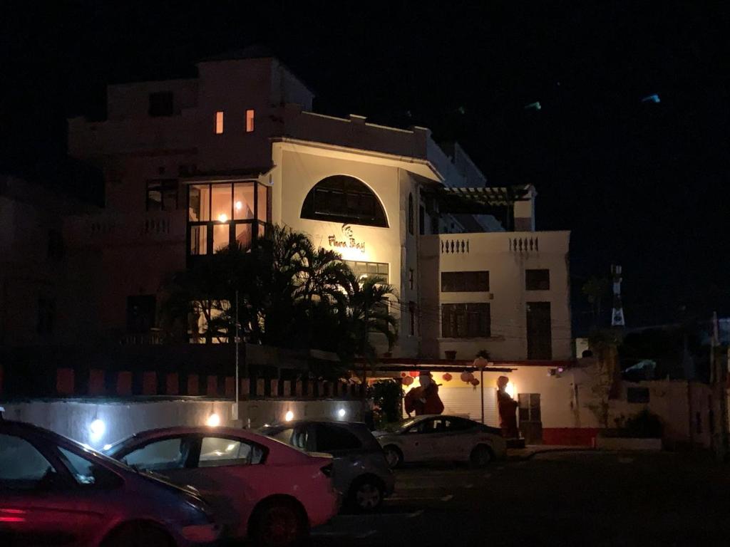 a white building with cars parked in front of it at night at Les Studios De Grand Baie in Grand Baie