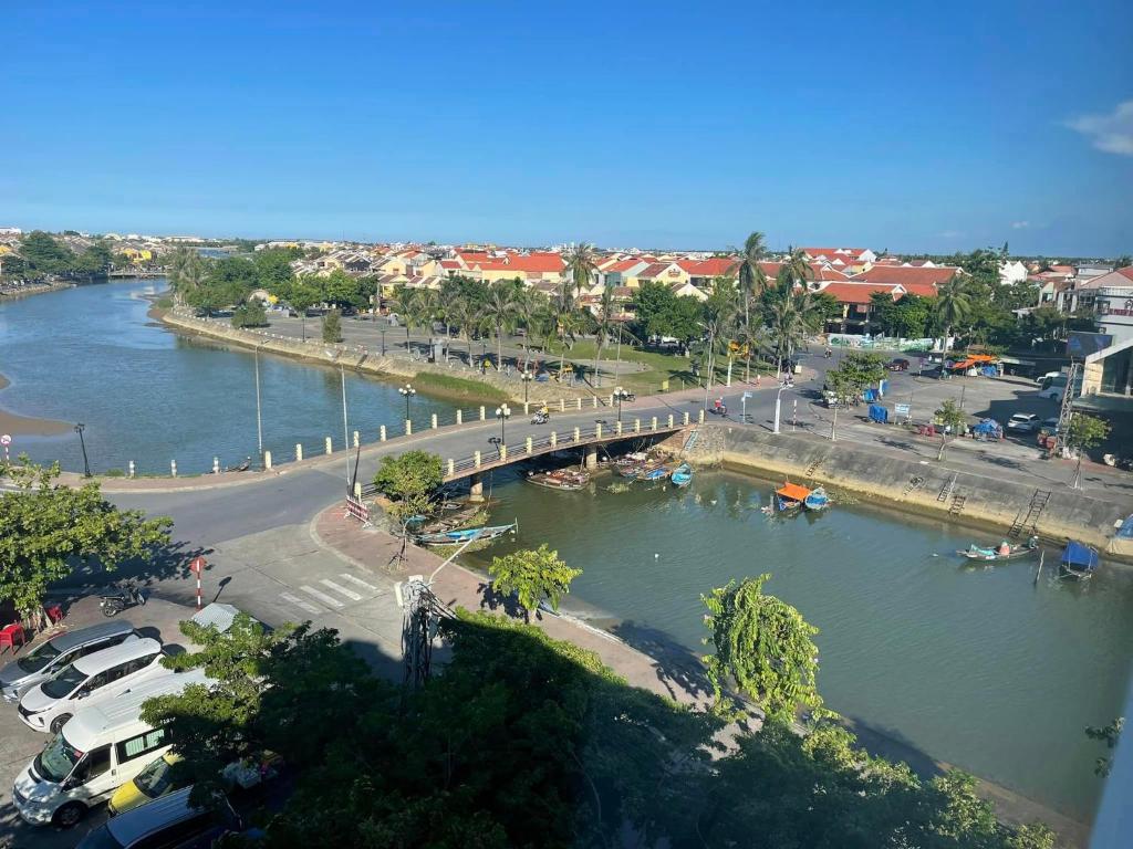 a view of a river with a bridge and cars at River Suites Hoi An in Hoi An