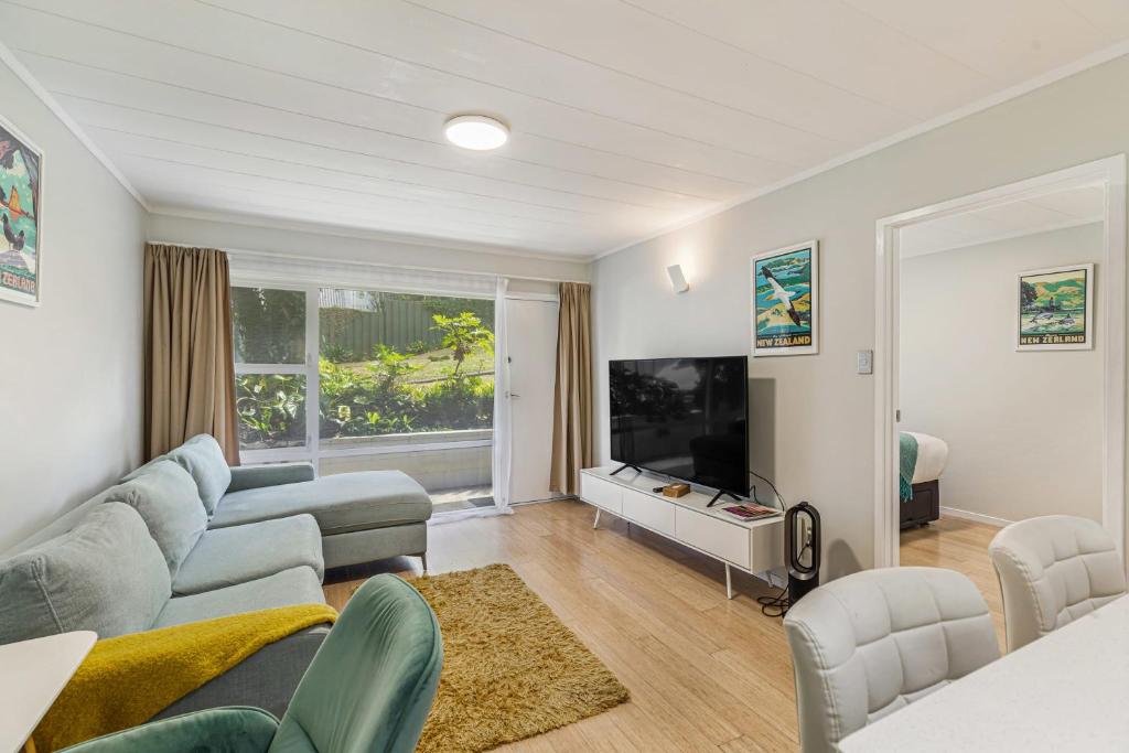 a living room with a couch and a flat screen tv at Herne Bay 1BR Retreat in Auckland