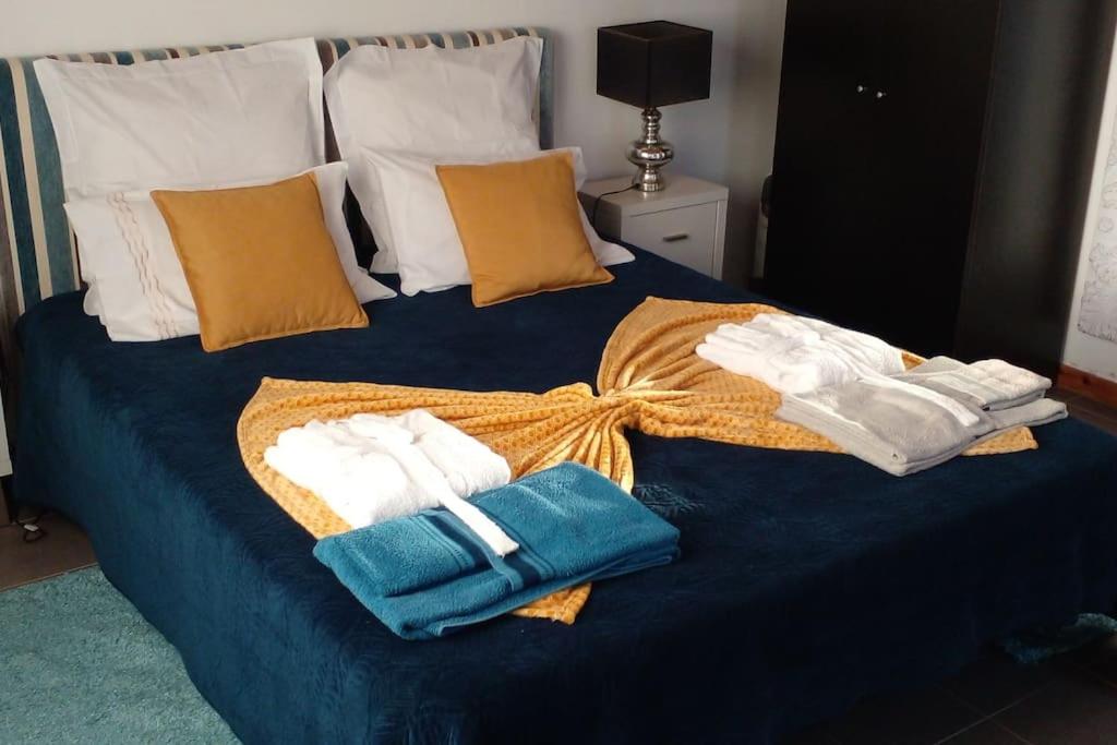 a blue bed with towels on top of it at Caloura Earth Accommodation in Caloura