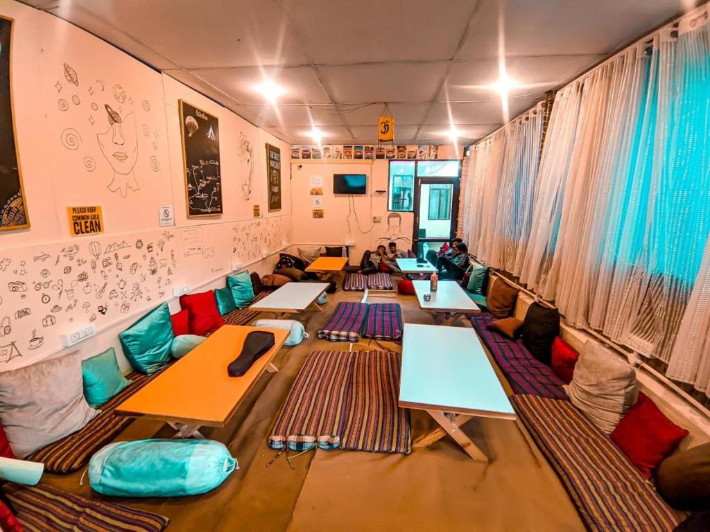 uma sala com fileiras de mesas e cadeiras em One More Night hostel and community living em McLeod Ganj