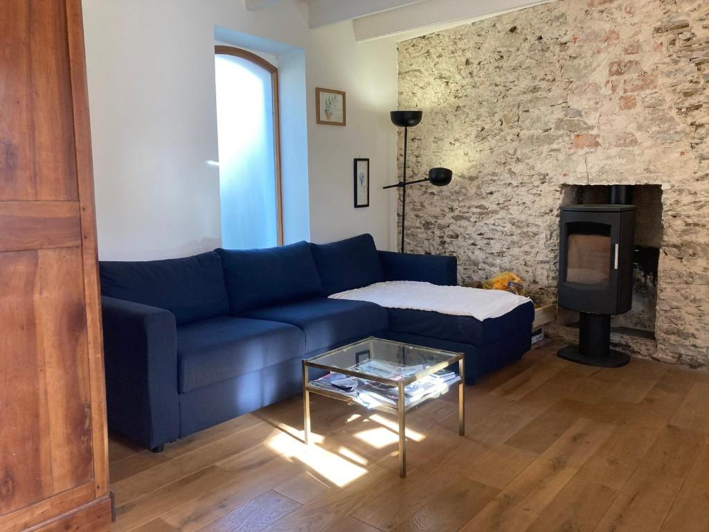 ein blaues Sofa im Wohnzimmer mit Kamin in der Unterkunft Maison Locmaria, 4 pièces, 6 personnes - FR-1-418-245 in Locmaria