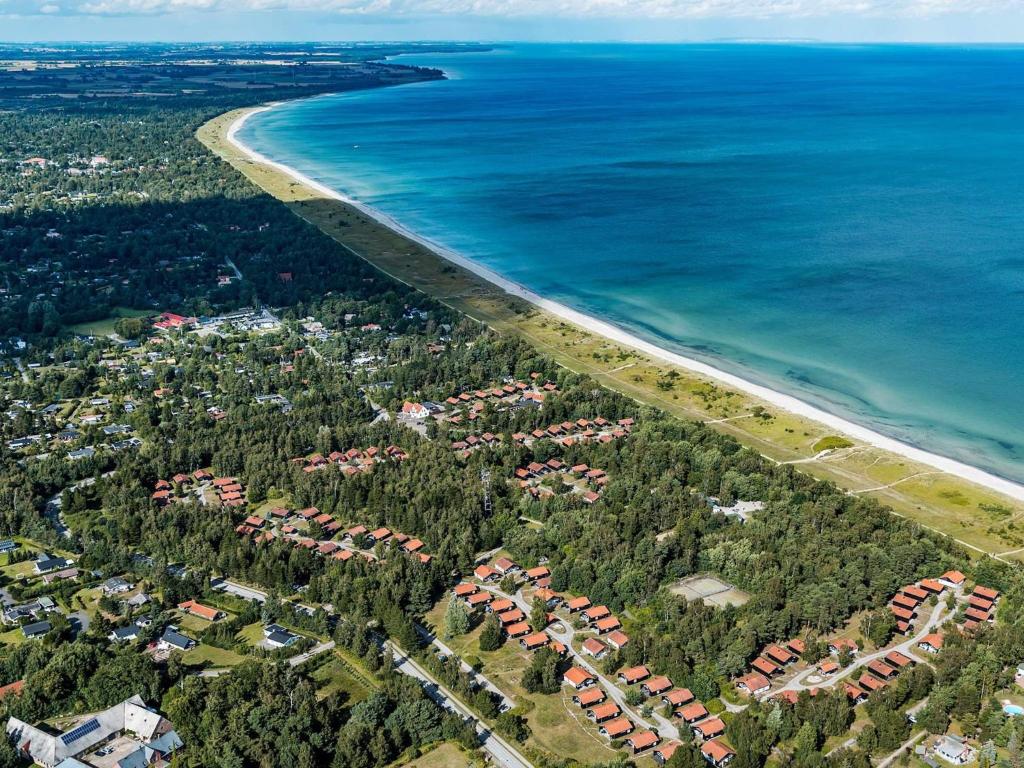 een luchtzicht op een strand met huizen en de oceaan bij 6 person holiday home on a holiday park in V ggerl se in Bøtø By