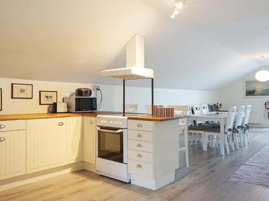 a kitchen with a stove top oven next to a table at 6 person holiday home in KUNGSHAMN in Kungshamn