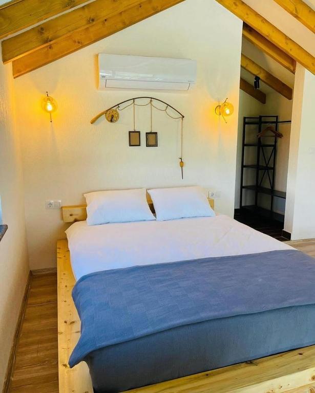 um quarto com uma grande cama branca com lençóis azuis em Villa La Altragracia em Constanza