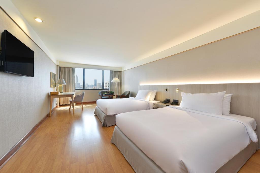 فندق توين تاورز في بانكوك: غرفه فندقيه سريرين وتلفزيون