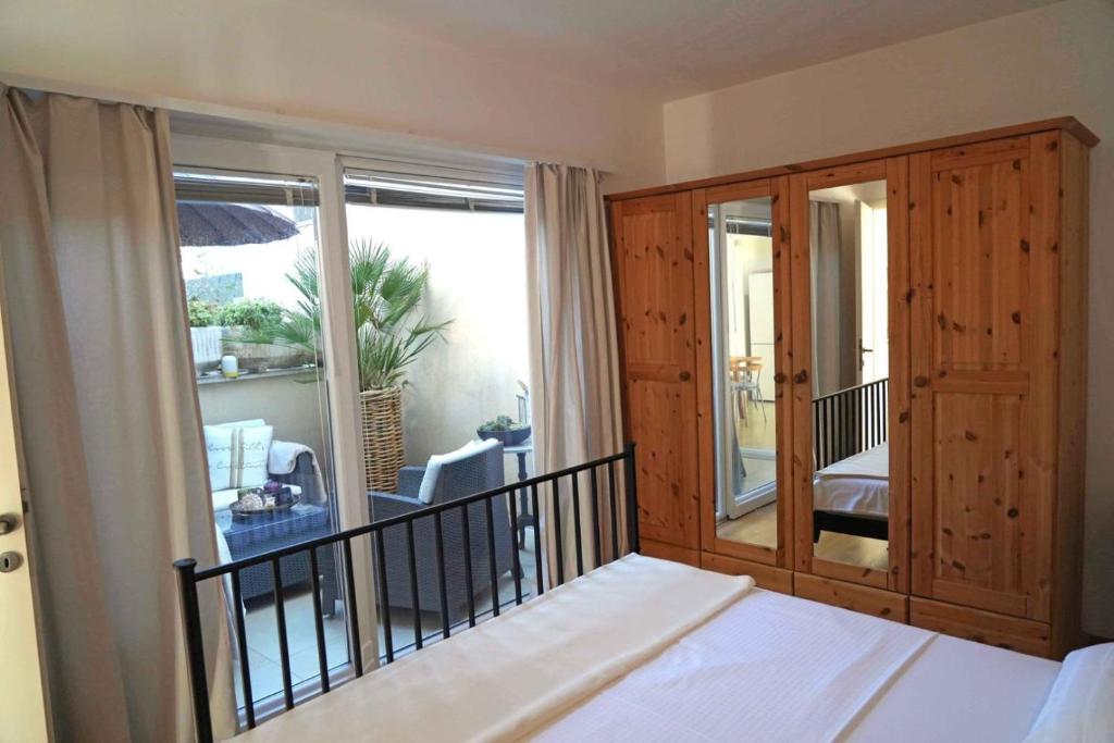a bedroom with a bed and a balcony with a view at Apartments Apartmani Oh La La - terrace in Supetar