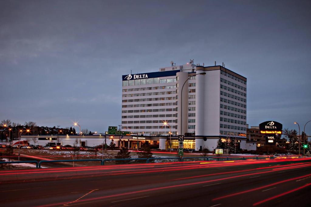 a large white building with a sign on top of it at Delta Hotels by Marriott Edmonton South Conference Centre in Edmonton