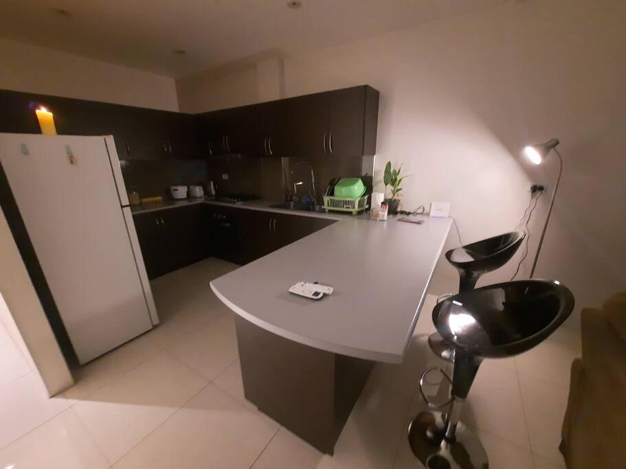 a kitchen with a white counter and a black chair at Bula Bliss in Nadi