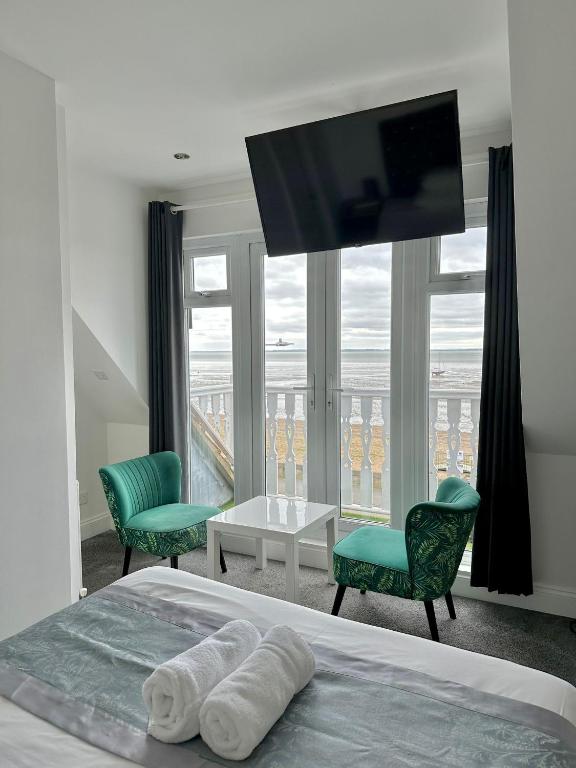 1 dormitorio con 1 cama con 2 sillas y TV en WNS Southend-on-Sea, en Southend-on-Sea