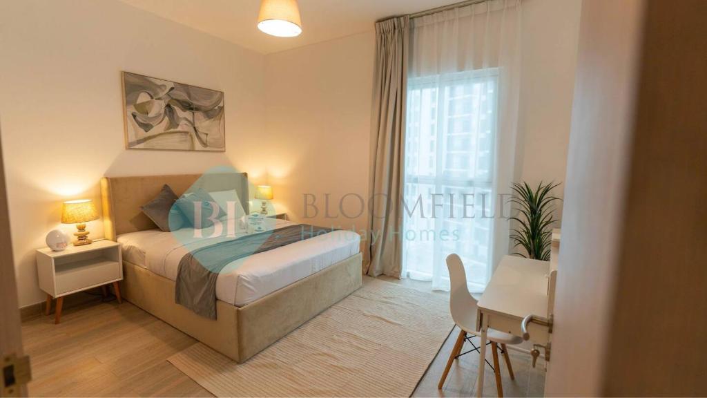 a bedroom with a bed and a desk and a window at Stylish 1bedroom In Water Edge in Abu Dhabi