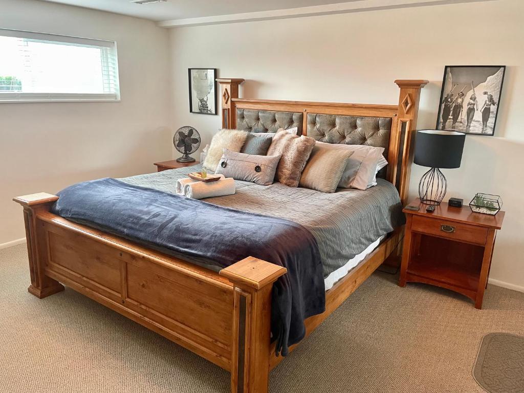 Un dormitorio con una gran cama de madera con almohadas en City light views getaway close to top ski resorts, en Salt Lake City