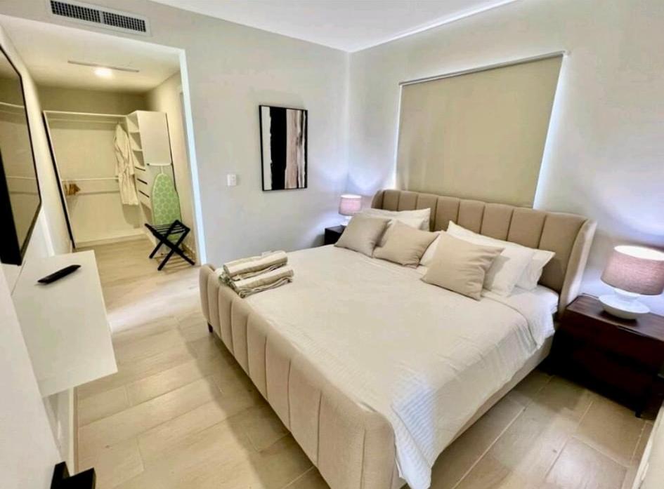 1 Schlafzimmer mit einem großen Bett und einem Badezimmer in der Unterkunft Luxury Golf View Penthouse - Pool+Gym+Beach+Fishing in Punta Cana