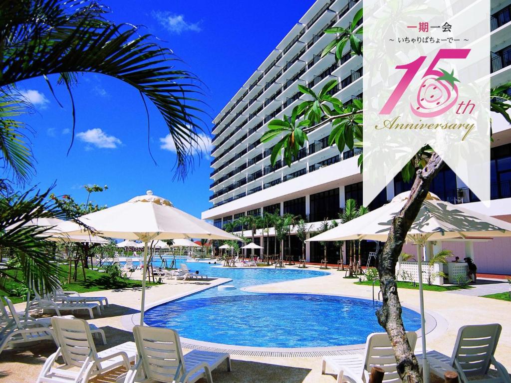 una piscina con sillas y sombrillas frente a un edificio en Southern Beach Hotel & Resort, en Itoman