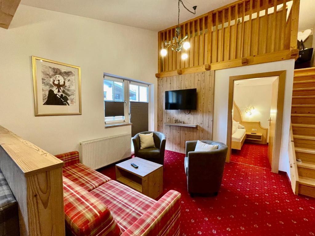 a living room with a couch and a chair at Arlen Lodge Appartement in Sankt Anton am Arlberg