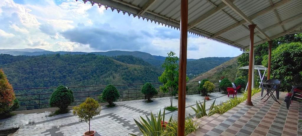 een balkon met uitzicht op de bergen bij Theeram Agro Farm Hill Resort Vagamon in Vagamon