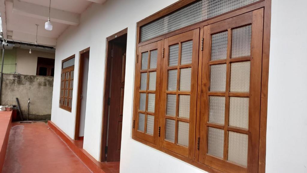 una fila de puertas de madera en una habitación en Royal Rich Villa Maskeliya en Maskeliya