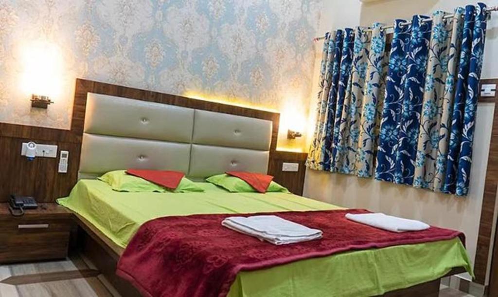 a bedroom with a bed with two towels on it at FabHotel CM Palace I in Varanasi