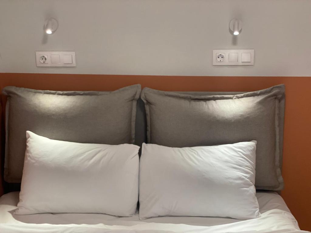a bed with two pillows and two lights above it at City Vibe-Sigrou 44 in Thessaloniki