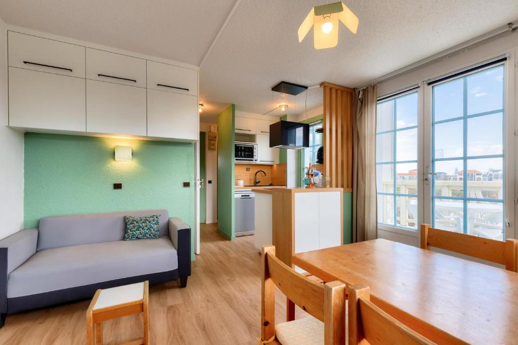 eine Küche und ein Wohnzimmer mit einem Tisch und einem Sofa in der Unterkunft Résidence Port Bourgenay - maeva Home - Appartement 2 pièces 4 personnes - 604 in Talmont