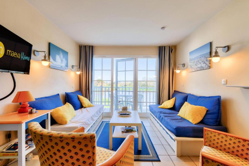 een woonkamer met een blauwe bank en een tv bij Résidence Port Bourgenay - maeva Home - Appartement 2 pièces 5 personnes - 864 in Talmont