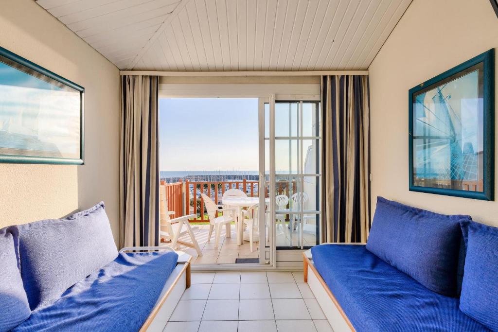 un salon avec un canapé bleu et un balcon dans l'établissement Résidence Port Bourgenay - maeva Home - Studio 5 personnes - Sélection MAE-7944, à Talmont-Saint-Hilaire