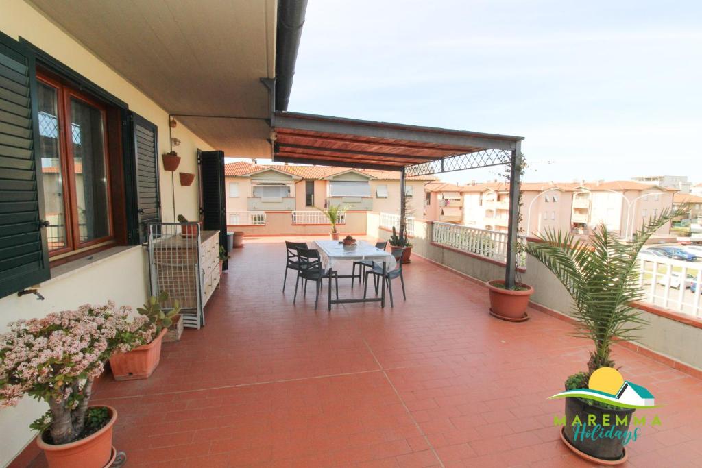 福洛尼卡的住宿－Maremma Holidays: Scogliera Apartment，阳台的天井配有桌椅