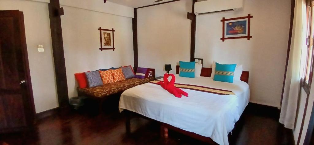 a bedroom with a bed with a red ribbon on it at Saynamkhan River View in Luang Prabang