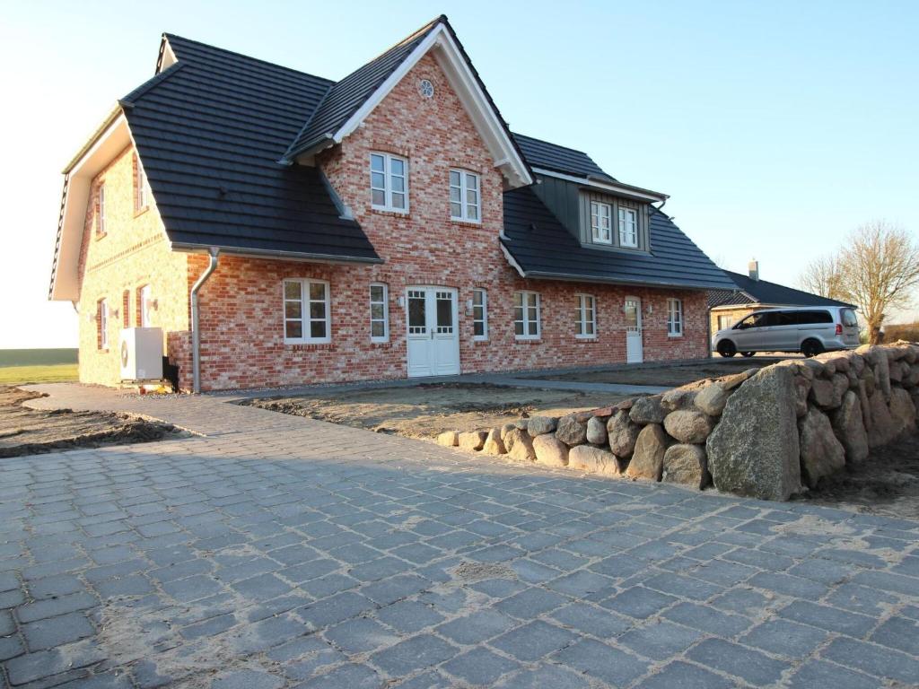 a red brick house with a black roof at Doppelhaushälfte in Karolinenkoog in Karolinenkoog