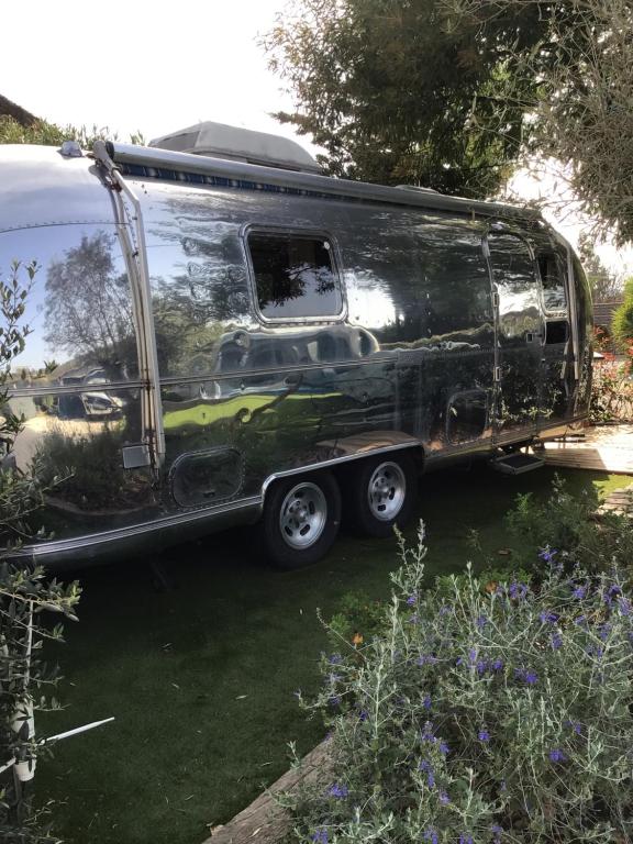 un remolque plateado de aire estacionado en un patio en Pooh’s Belle en Grimaud