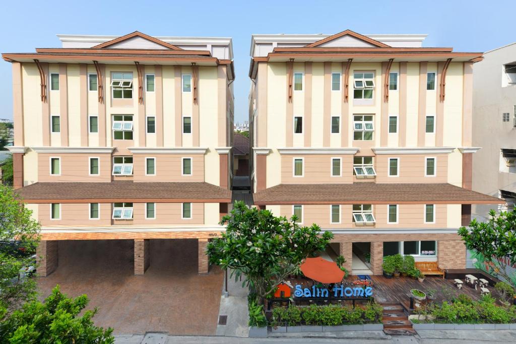 dos edificios altos con árboles delante de ellos en Salin Home Hotel Ramkhamhaeng, en Bangkok