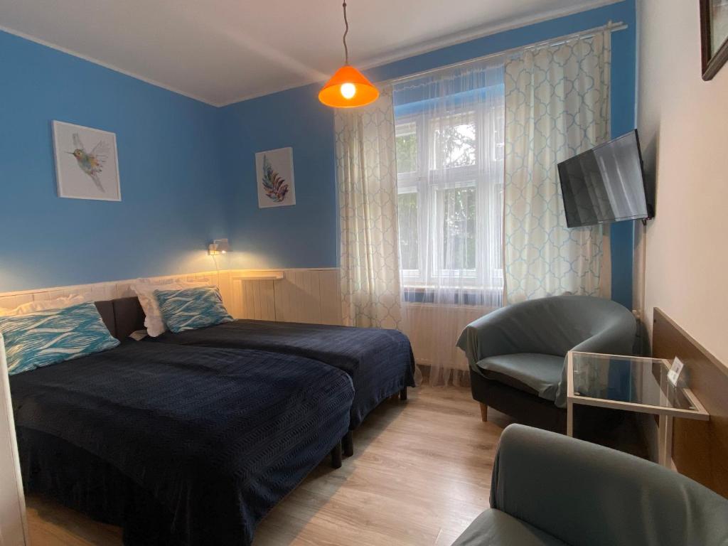 カルパチにあるPod Jeleńcemのベッドルーム1室(ベッド1台、椅子、窓付)