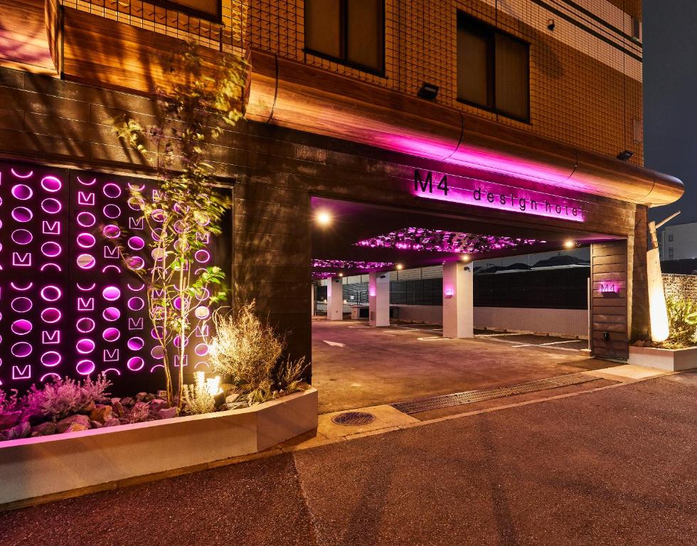 東京的住宿－M4 design hotel，建筑的侧面有紫色的灯