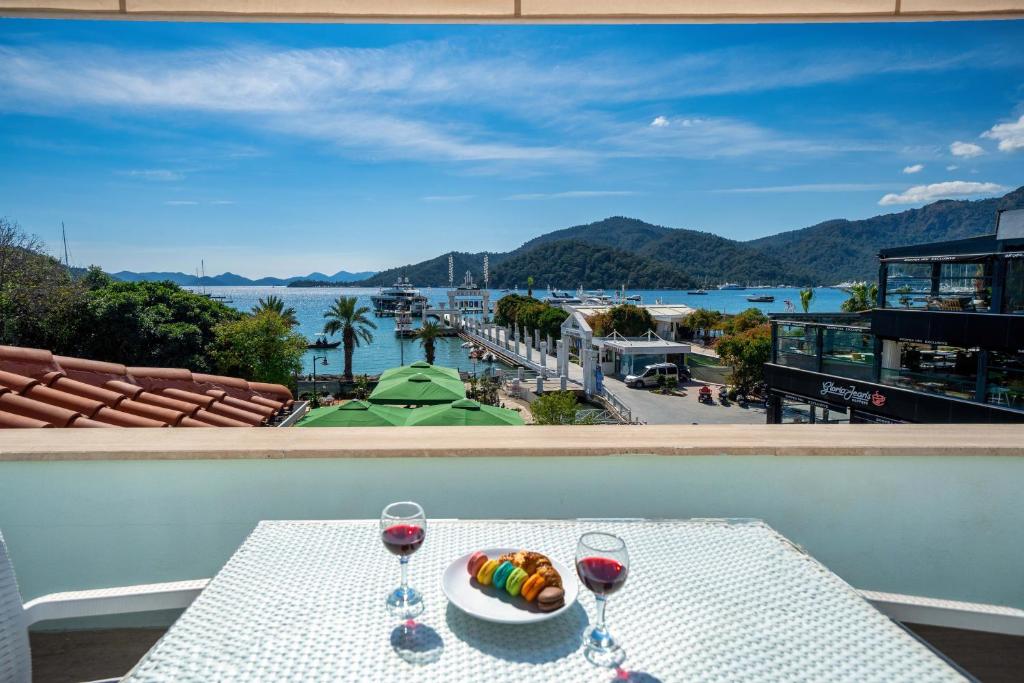 a table with two wine glasses and a plate of food at Dedeminn Garden House in Göcek