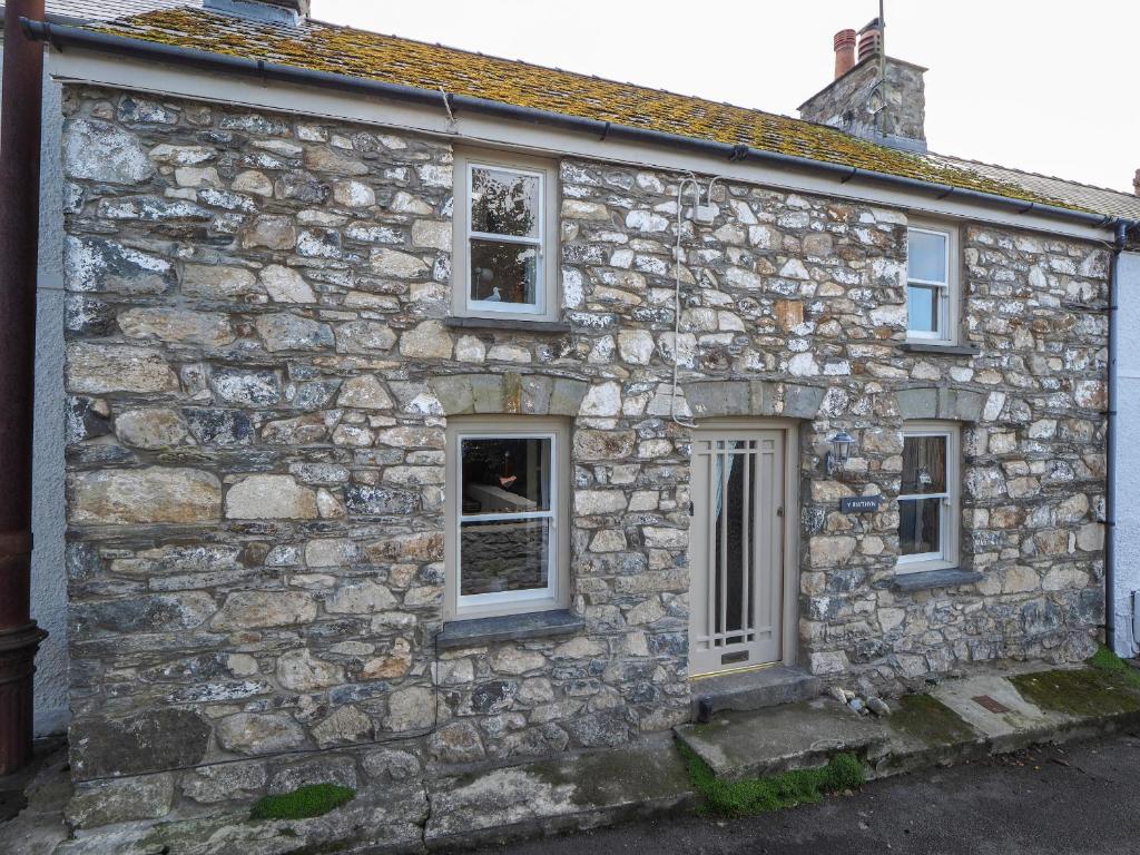 an old stone house with three windows at Y Bwthyn Newport in Newport Pembrokeshire