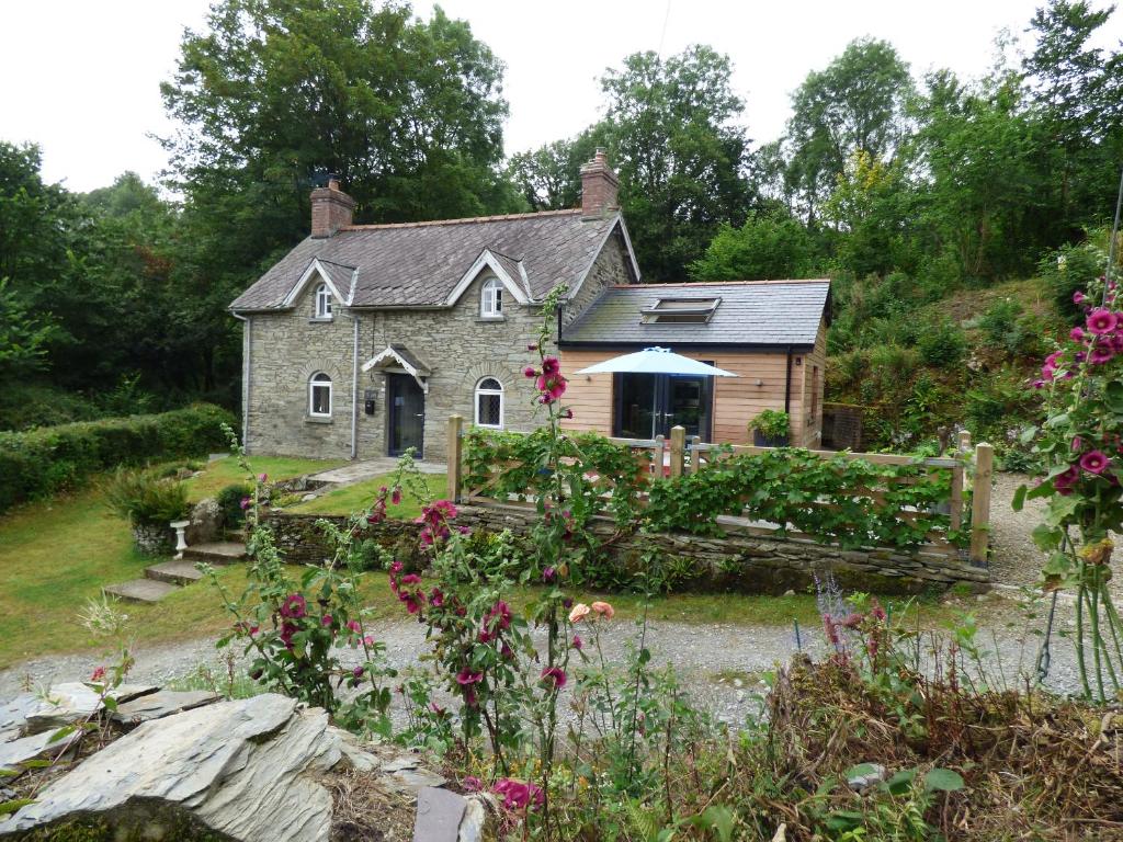 an old stone house with a garden in front of it at Ty Cam Abercych in Abercych