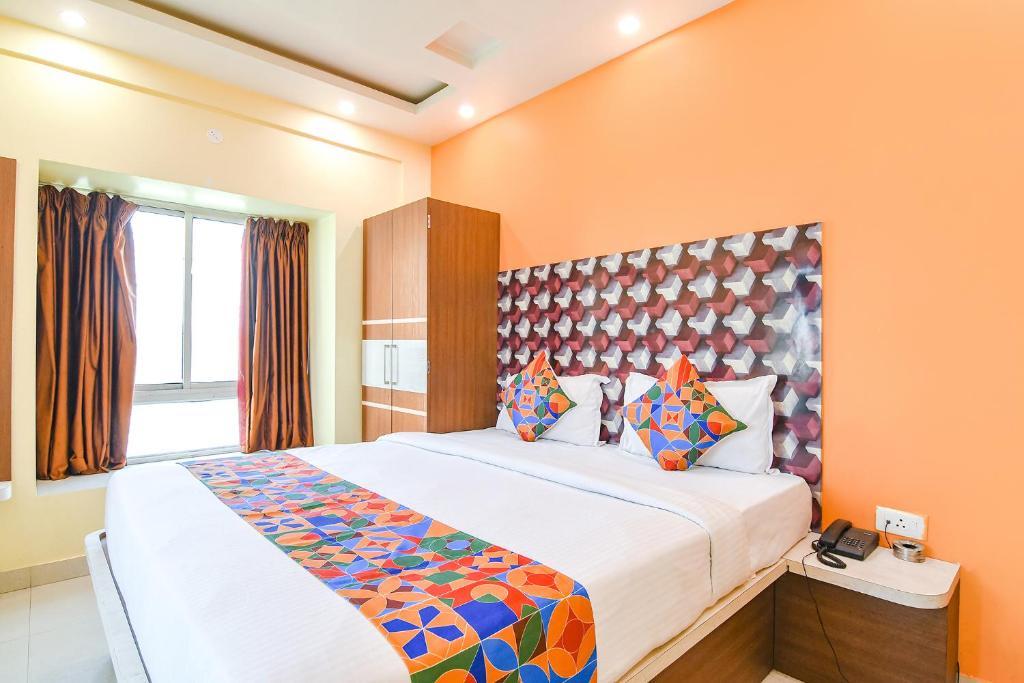 um quarto com uma cama grande e paredes cor-de-laranja em FabHotel Angel The Golden Key em Jojera