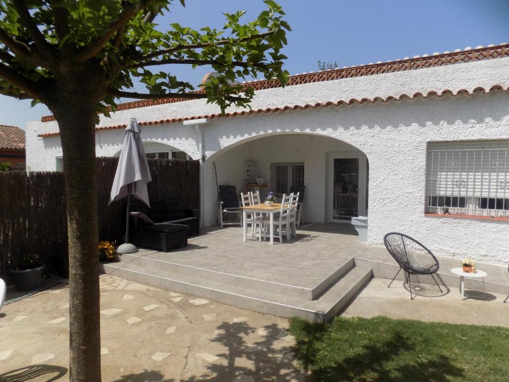 une terrasse avec une table, des chaises et un parasol dans l'établissement Bon Repos 2, à Torroella de Montgrí