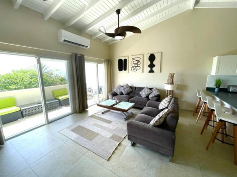 a living room with a couch and a table at New* Tropical Modern Townhouse in SXM in Simpson Bay