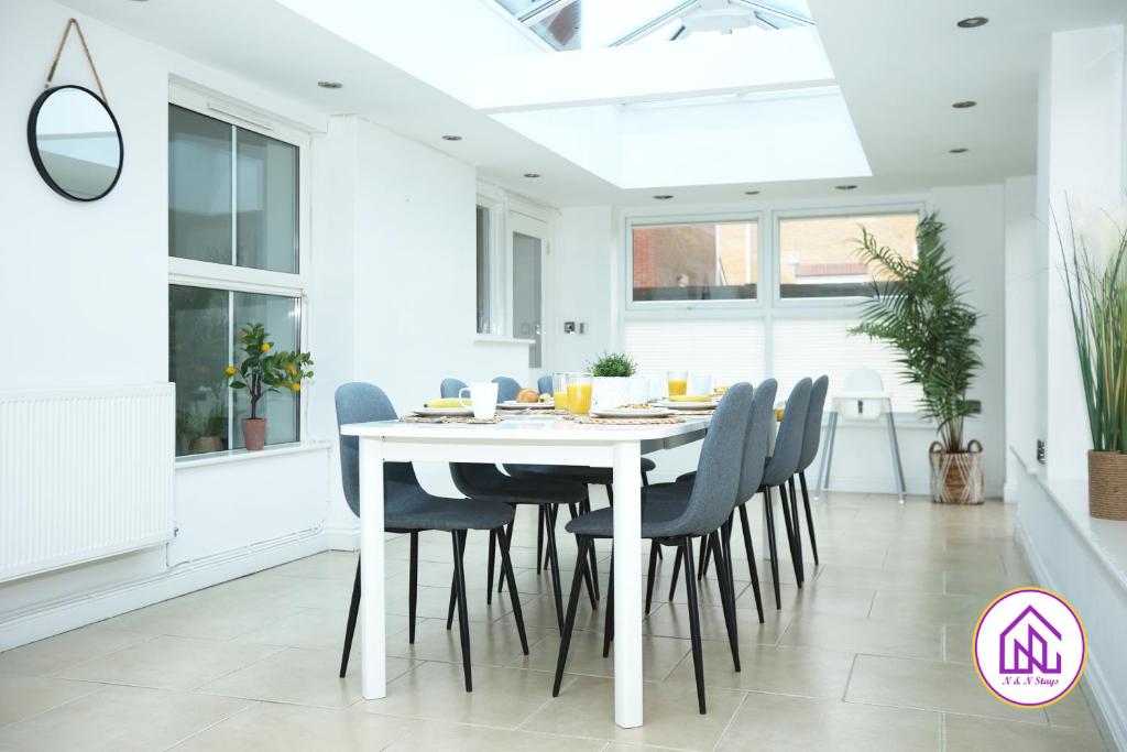 biała jadalnia z białym stołem i krzesłami w obiekcie Milestone House, Large Modern House, Free Parking w Cardiff