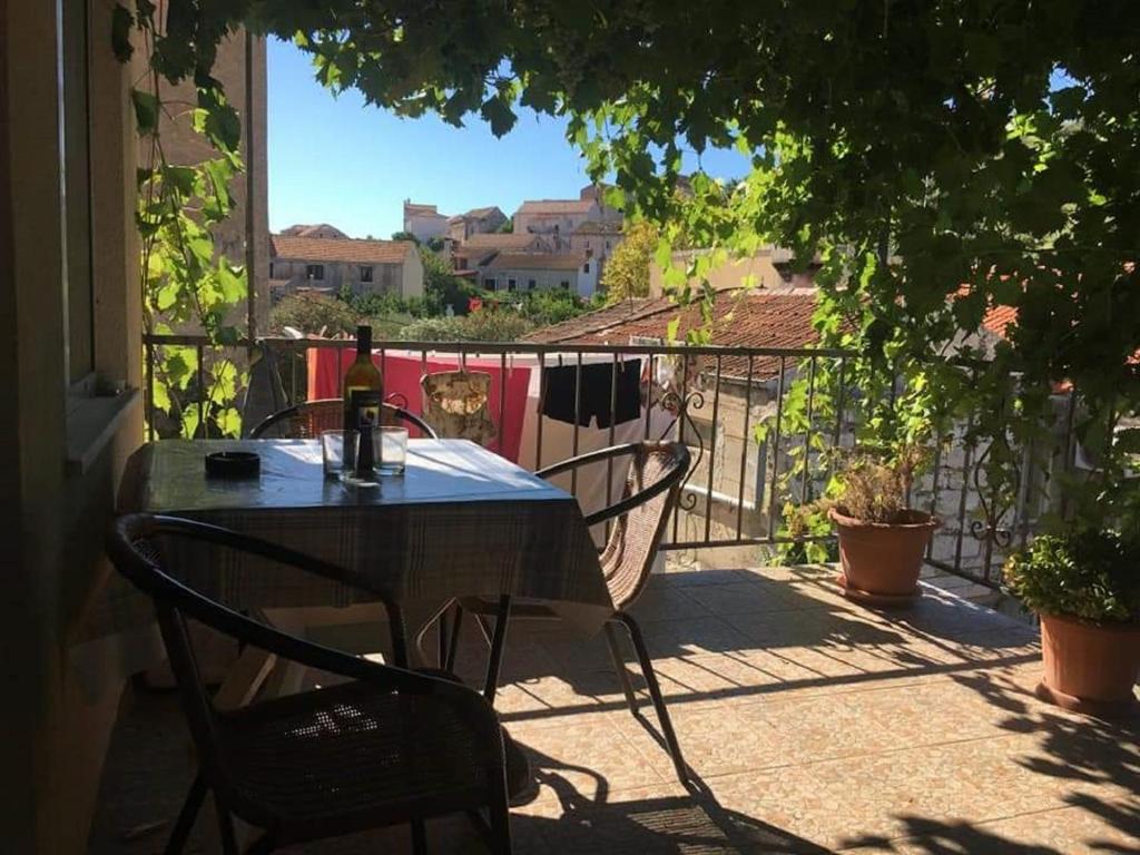 einen Tisch mit einer Flasche Wein auf dem Balkon in der Unterkunft Apartment Brezak in Lastovo