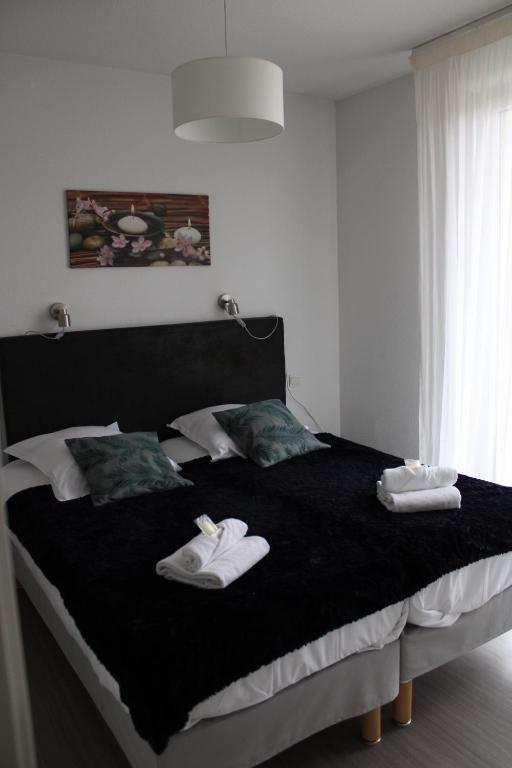 a bedroom with a large bed with towels on it at City Lodge Appart Hôtel Niort in Niort