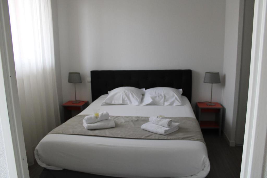 a bedroom with a bed with two towels on it at City Lodge Appart Hôtel Niort in Niort