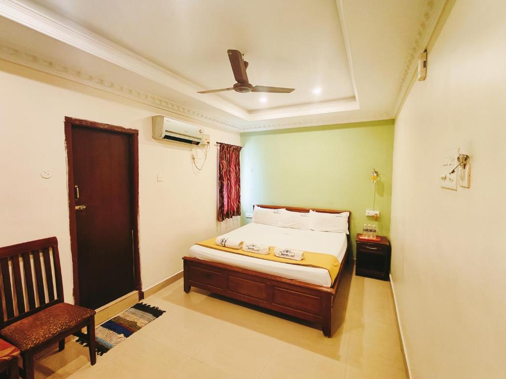 - une chambre avec un lit et une chaise dans l'établissement Hotel Harish, à Rameswaram